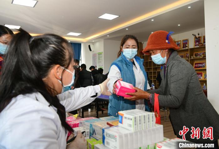 图为义诊赠药。　贡嘎来松 摄
